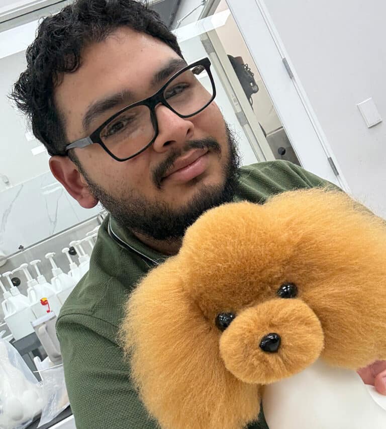 Groomer holding a freshly groomed dog